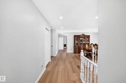 Spacious hallway featuring wood-finish flooring, recessed lighting, and white baseboards - 6208 11 Ave Nw Nw, Edmonton, AB - Indoor Photo Showing Other Room