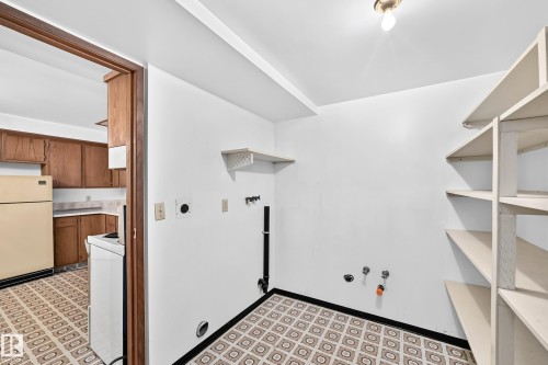 Laundry area with patterned tile flooring, built-in shelving, and white walls - 6208 11 Ave Nw Nw, Edmonton, AB - Indoor