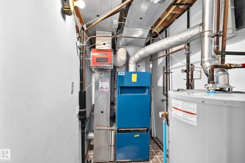 Mechanical room featuring a water heater, furnace, and exposed ductwork - 6208 11 Ave Nw Nw, Edmonton, AB - Indoor Photo Showing Basement