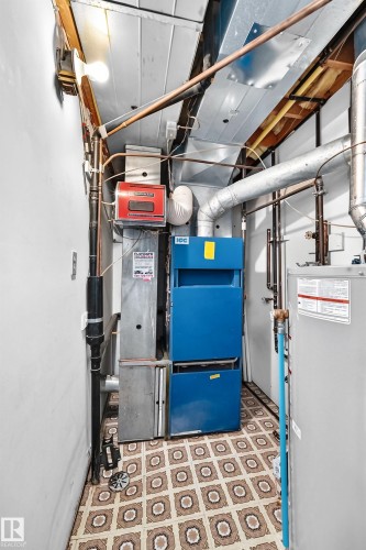 Utility area featuring a water heater, furnace, and exposed copper piping - 6208 11 Ave Nw Nw, Edmonton, AB - Indoor Photo Showing Basement