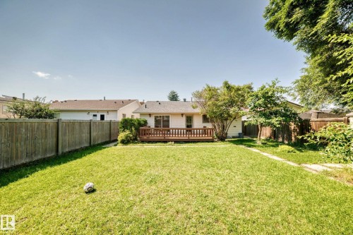 Expansive backyard featuring a wood-finish deck, mature trees, and a wooden privacy fence - 6208 11 Ave Nw Nw, Edmonton, AB - Outdoor With Deck Patio Veranda