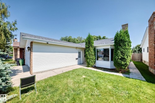 This property features white siding, a prominent bay window, and a brick chimney - 6208 11 Ave Nw Nw, Edmonton, AB - Outdoor