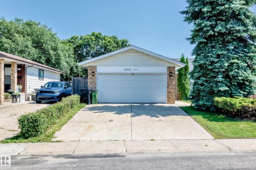 Single-story residence featuring a white garage door, brick accents, and light-colored siding - 6208 11 Ave Nw Nw, Edmonton, AB - Outdoor