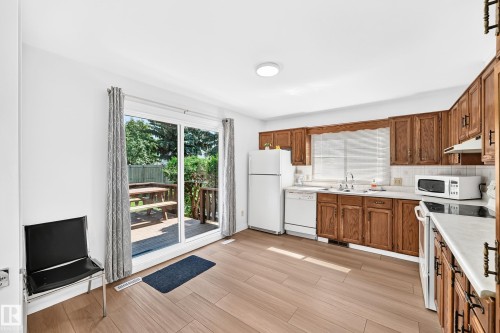 Kitchen featuring wood-finish flooring, wood cabinetry, and white countertops - 6208 11 Ave Nw Nw, Edmonton, AB - Indoor Photo Showing Kitchen