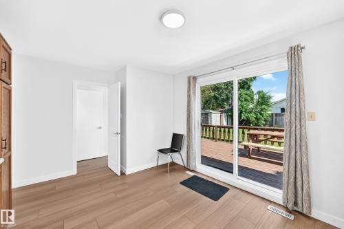 Expansive sliding glass doors opening to a wood deck - 6208 11 Ave Nw Nw, Edmonton, AB - Indoor Photo Showing Other Room