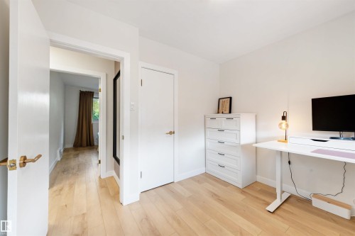 Bright room featuring light wood-finish flooring, white walls, and white trim - 10732 129 Street Nw, Edmonton, AB - Indoor