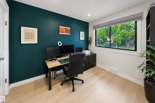 Room featuring a deep teal accent wall and light wood-finish flooring - 10732 129 Street Nw, Edmonton, AB - Indoor Photo Showing Office