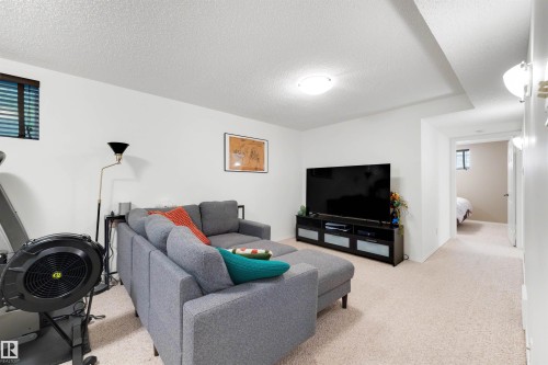 Carpeted living area featuring a drop ceiling, recessed lighting, and a window with horizontal blinds - 10732 129 Street Nw, Edmonton, AB - Indoor Photo Showing Living Room