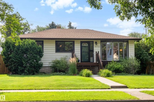 Ranch-style exterior featuring light-colored horizontal siding, a brown shingle roof, and dark trim details - 10732 129 Street Nw, Edmonton, AB - Outdoor