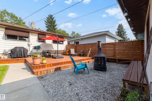 Multi-level wood deck featuring built-in seating, a gravel patio area, and a horizontal wood privacy fence - 10732 129 Street Nw, Edmonton, AB - Outdoor With Deck Patio Veranda With Exterior