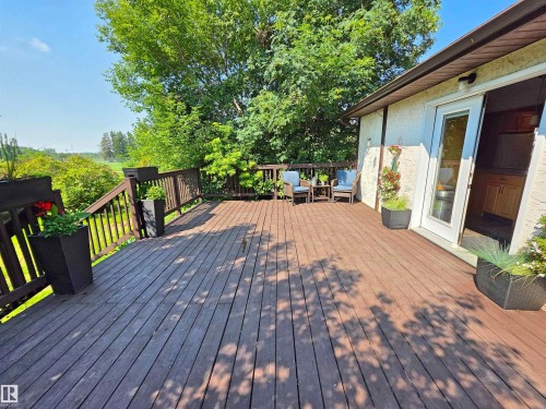 Expansive rear deck featuring dark wood-finish railing and stairs - 3003 Park Avenue, Mallaig, AB - Outdoor