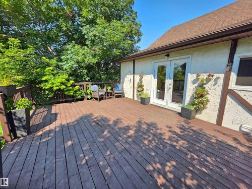Expansive wood-finish deck with dark wood railings and a direct access door - 3003 Park Avenue, Mallaig, AB - Outdoor With Deck Patio Veranda
