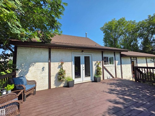 Outdoor wood-finish deck featuring a slatted railing and steps descending to a grassy area - 3003 Park Avenue, Mallaig, AB - Outdoor With Deck Patio Veranda