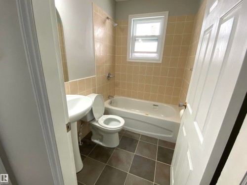 Bathroom featuring a pedestal sink, toilet, and bathtub with shower fixture - 12010 66 Street Nw, Edmonton, AB - Indoor Photo Showing Bathroom