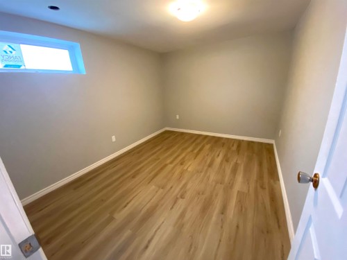Room featuring wood-finish flooring, light gray walls, and white baseboards - 12010 66 Street Nw, Edmonton, AB - Indoor Photo Showing Other Room