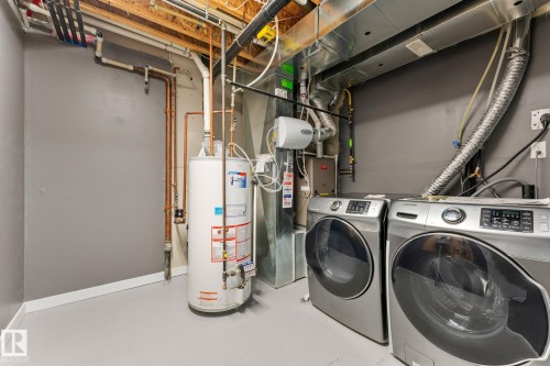 Dedicated utility area featuring a water heater, furnace, and exposed ductwork - #18 7289 South Terwillegar Dr Nw, Edmonton, AB - Indoor Photo Showing Laundry Room