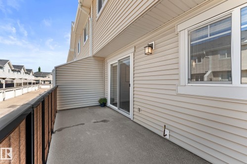 Private concrete balcony with a black metal and composite railing - #18 7289 South Terwillegar Dr Nw, Edmonton, AB - Outdoor With Exterior
