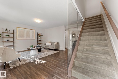 Carpeted staircase with glass panel railing and wood handrail - #18 7289 South Terwillegar Dr Nw, Edmonton, AB - Indoor Photo Showing Other Room