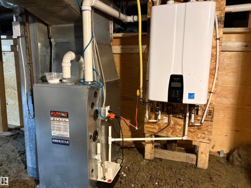 Updated HVAC system featuring a galvanized metal furnace and an energy-efficient tankless water heater - 4901 53 Avenue, Elk Point, AB - Indoor Photo Showing Basement