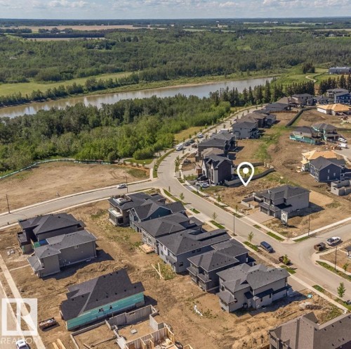 Aerial perspective showcasing a residential development with a river and forested areas in the background - 3505 Keswick Boulevard Sw, Edmonton, AB 