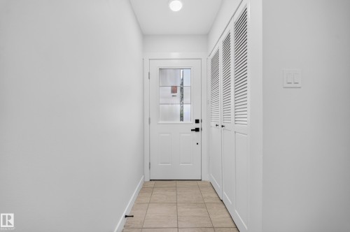 Entryway featuring a paneled door with glass inserts, matte black hardware, and an overhead flush-mount light - 5204 97A Avenue Nw, Edmonton, AB - Indoor Photo Showing Other Room