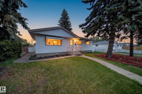 White siding exterior with a pitched roof, featuring a concrete front walkway and steps with metal railings - 5204 97A Avenue Nw, Edmonton, AB - Outdoor