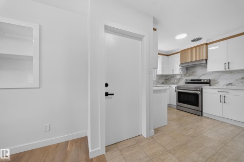 Contemporary kitchen featuring white cabinetry, stainless steel range, and marbled countertops - 5204 97A Avenue Nw, Edmonton, AB - Indoor Photo Showing Kitchen