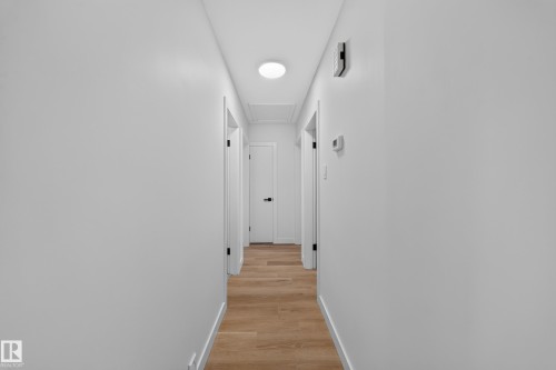 Hallway featuring wood-finish flooring, white baseboards, and white walls - 5204 97A Avenue Nw, Edmonton, AB - Indoor Photo Showing Other Room