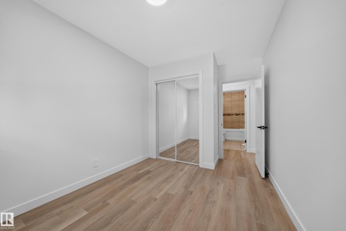 Room featuring wood-finish flooring, light grey painted walls, and white trim - 5204 97A Avenue Nw, Edmonton, AB - Indoor Photo Showing Other Room