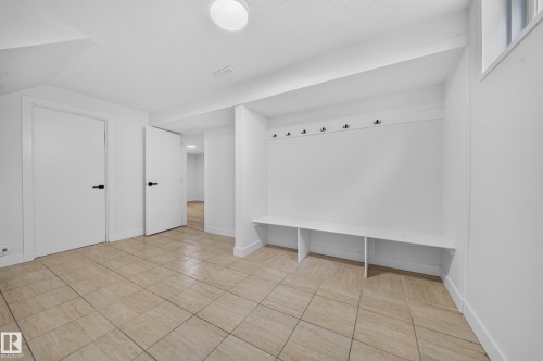Entryway featuring built-in bench seating with cubbies, multiple coat hooks, and durable tile flooring - 5204 97A Avenue Nw, Edmonton, AB - Indoor Photo Showing Other Room