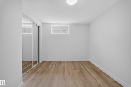 Room featuring light wood-finish flooring, white painted walls, and white baseboards - 5204 97A Avenue Nw, Edmonton, AB - Indoor Photo Showing Other Room