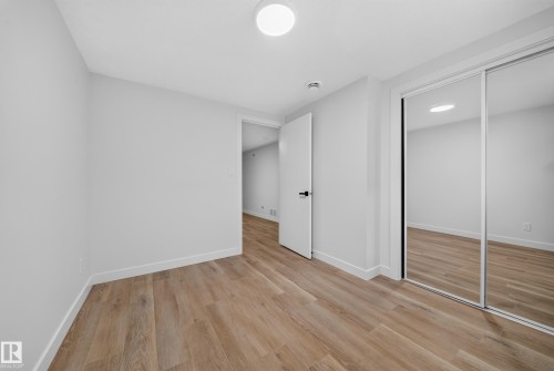 Room featuring wood-finish flooring, white baseboards, and light gray walls - 5204 97A Avenue Nw, Edmonton, AB - Indoor Photo Showing Other Room