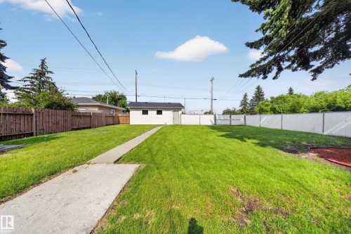 Expansive grass lawn with concrete pathway leading to a detached garage - 5204 97A Avenue Nw, Edmonton, AB - Outdoor
