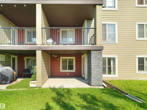 Ground-level patio with concrete flooring, accented by a stacked stone column - #109 3207 James Mowatt Tr Sw, Edmonton, AB - Outdoor With Exterior