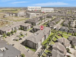 Multi-story residential building with a grey shingle roof and balconies, surrounded by paved parking areas - 