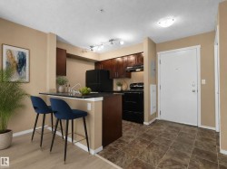 Kitchen featuring dark wood cabinetry, black appliances, and a breakfast bar with a contrasting countertop - 