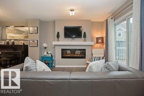 #95 4050 Savaryn Dr Sw, Edmonton, AB - Indoor Photo Showing Living Room With Fireplace