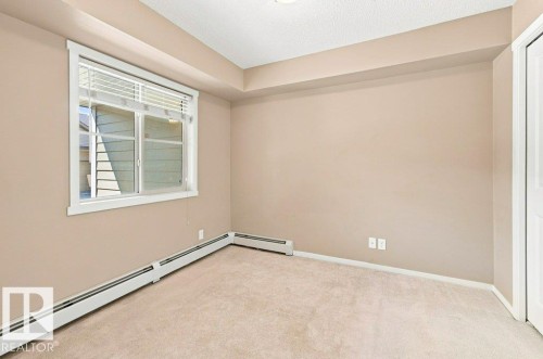 Room featuring neutral-toned walls, plush carpeting, and a window with white blinds - #119 111 Watt Cm Sw, Edmonton, AB - Indoor Photo Showing Other Room