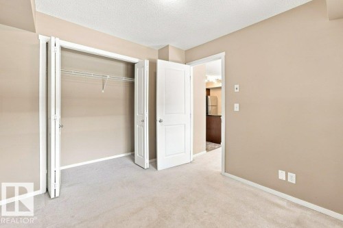 Neutral-toned room featuring light beige walls and light gray carpeted flooring - #119 111 Watt Cm Sw, Edmonton, AB - Indoor Photo Showing Other Room