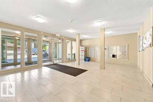 Inviting entryway featuring extensive tile flooring, neutral wall paint, recessed lighting, and a wall of glass doors providing abundant natural light - #119 111 Watt Cm Sw, Edmonton, AB - Indoor Photo Showing Other Room