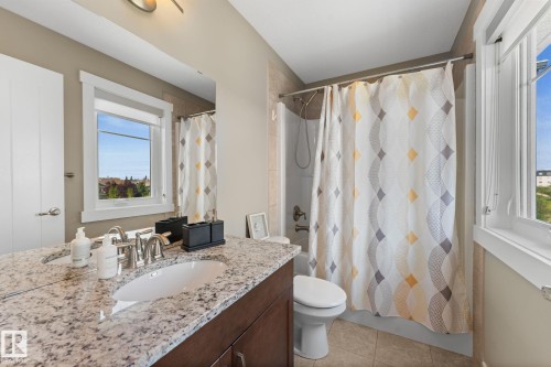 Bathroom featuring a single vanity with a granite countertop, undermount sink, and brushed nickel faucet - 3413 Cameron Heights Cove Nw, Edmonton, AB - Indoor Photo Showing Bathroom