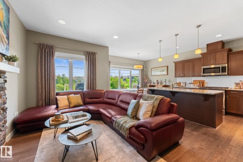 Open-concept living space with wood-finish flooring, recessed lighting, and large windows - 3413 Cameron Heights Cove Nw, Edmonton, AB - Indoor