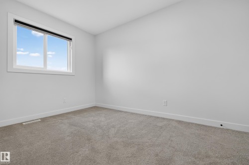 Neutral-toned wall paint with coordinating gray carpet - 1534 Plum Circle Circle Sw, Edmonton, AB - Indoor Photo Showing Other Room