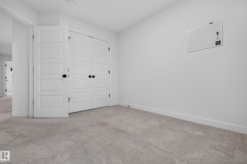 Interior room featuring light gray carpet flooring, white baseboards, and a neutral wall color - 1534 Plum Circle Circle Sw, Edmonton, AB - Indoor Photo Showing Other Room