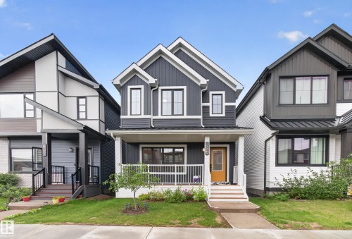Contemporary facade with dark gray siding and white trim accents - 1534 Plum Circle Circle Sw, Edmonton, AB - Outdoor With Facade