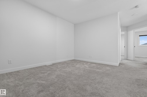 Spacious room featuring light gray carpeting and white walls - 1534 Plum Circle Circle Sw, Edmonton, AB - Indoor Photo Showing Other Room