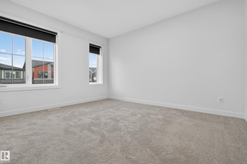 Spacious room featuring light gray carpeting and white painted walls - 1534 Plum Circle Circle Sw, Edmonton, AB - Indoor Photo Showing Other Room