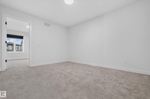 Neutral-toned carpeting throughout - 1534 Plum Circle Circle Sw, Edmonton, AB - Indoor Photo Showing Other Room