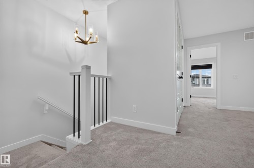 Upper landing with neutral carpeting and bright white walls - 1534 Plum Circle Circle Sw, Edmonton, AB - Indoor Photo Showing Other Room