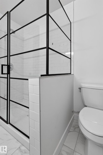 Walk-in shower featuring black-framed glass enclosure, white subway tile surround, white shower pan, and polished chrome fixtures - 1534 Plum Circle Circle Sw, Edmonton, AB - Indoor Photo Showing Bathroom
